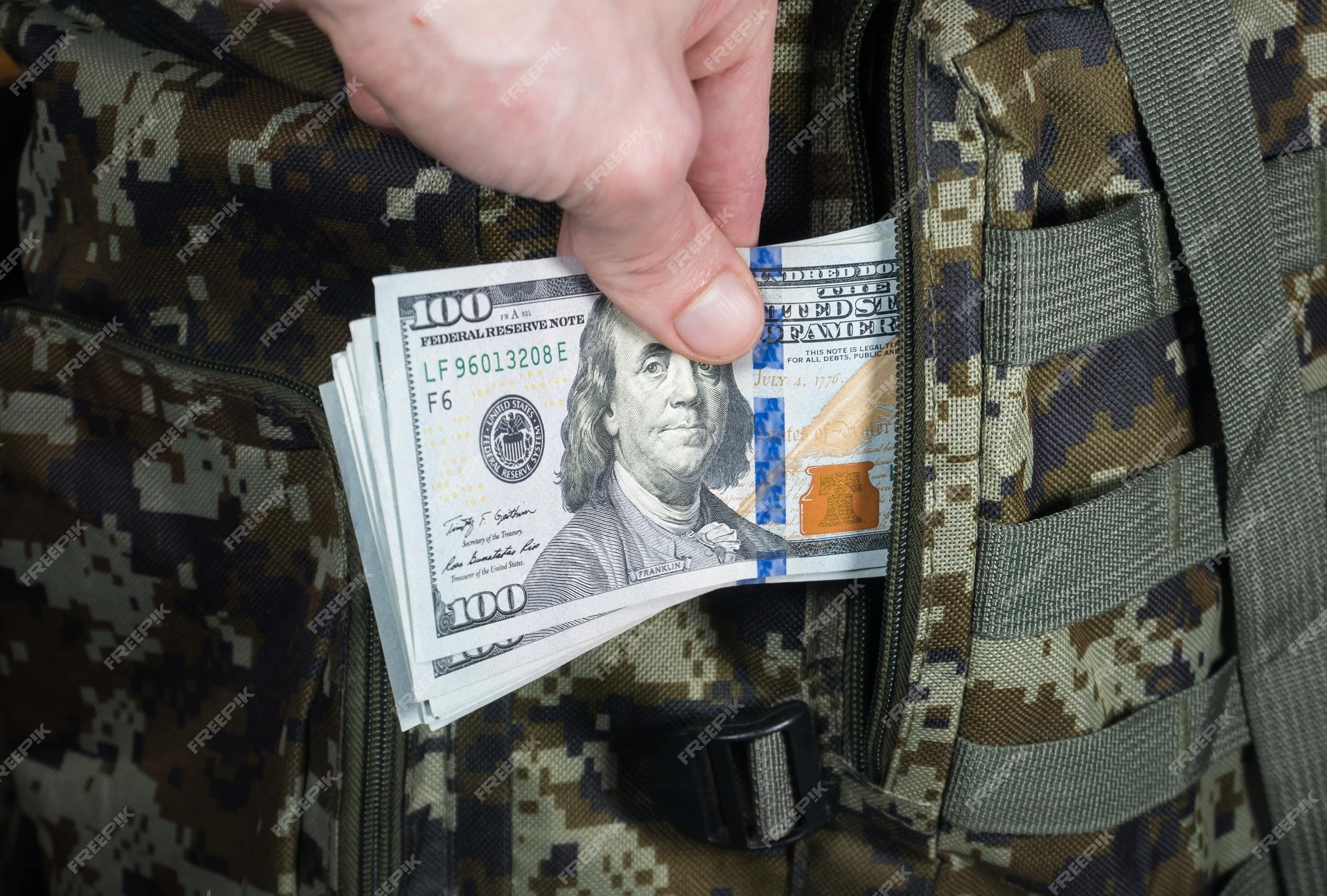 man-is-putting-military-backpack-dollarsxadark-green-camouflage-khaki-bag-with-money-migrants-refugees-concept_370059-6562.jpg