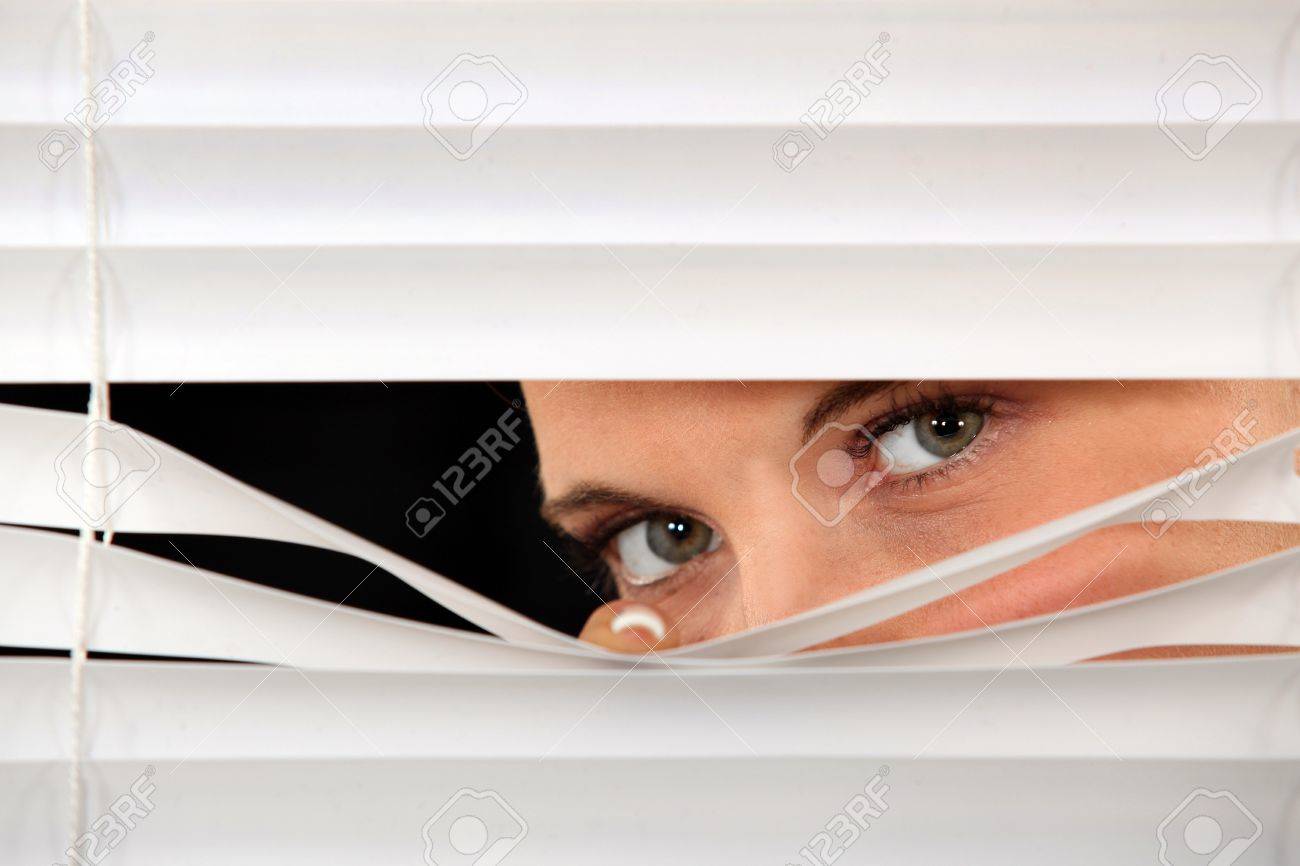14195053-woman-peeking-through-venetian-blinds.jpg