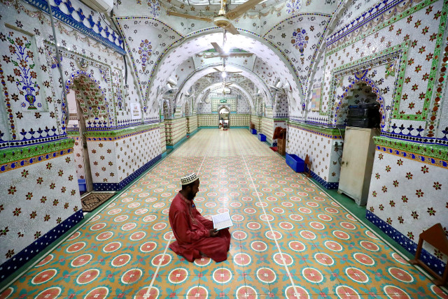 A Muslim devotee recites the Koran at the Star Mosque during Ramadan in Dhaka, Bangladesh, April 26, 2020 (photo credit: REUTERS/MOHAMMAD PONIR HOSSAIN)