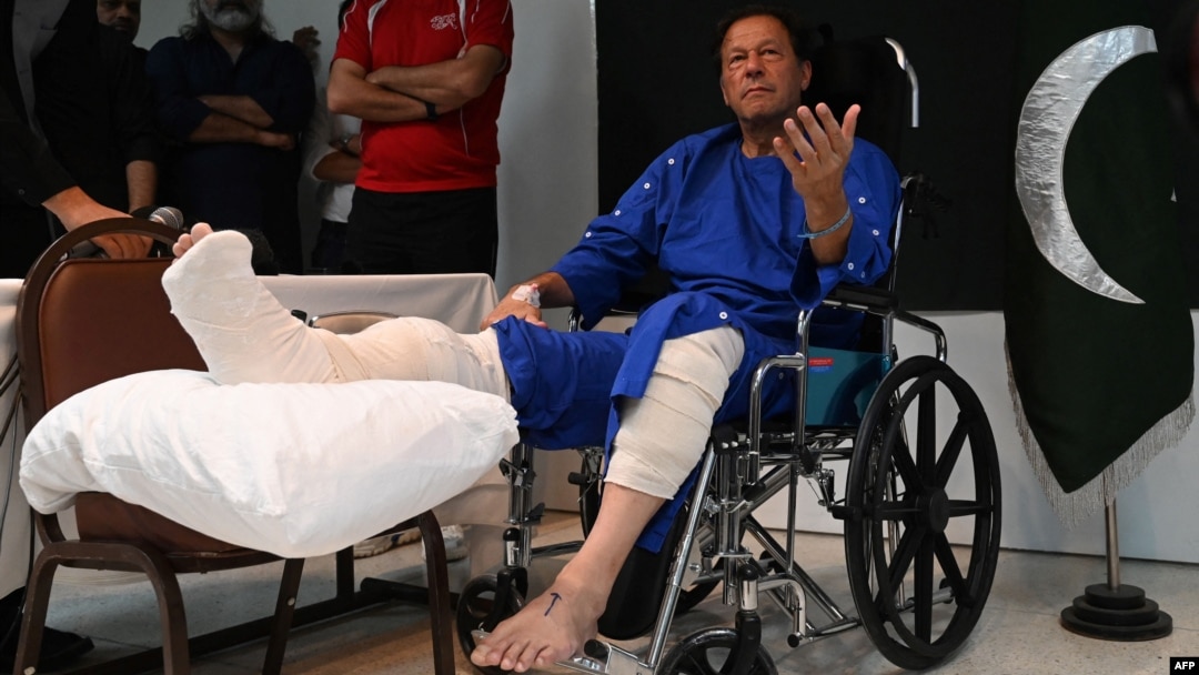 FILE - Pakistan's former prime minister Imran Khan talks with the media at a hospital in Lahore, Nov. 4, 2022, a day after an assassination attempt on him during his rally near Wazirabad.