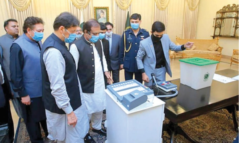 Prime Minister Imran Khan and ministers Shibli Faraz and Fawad Chaudhry view a demonstration of a locally made electronic voting machine on Aug 5. — White Star/File