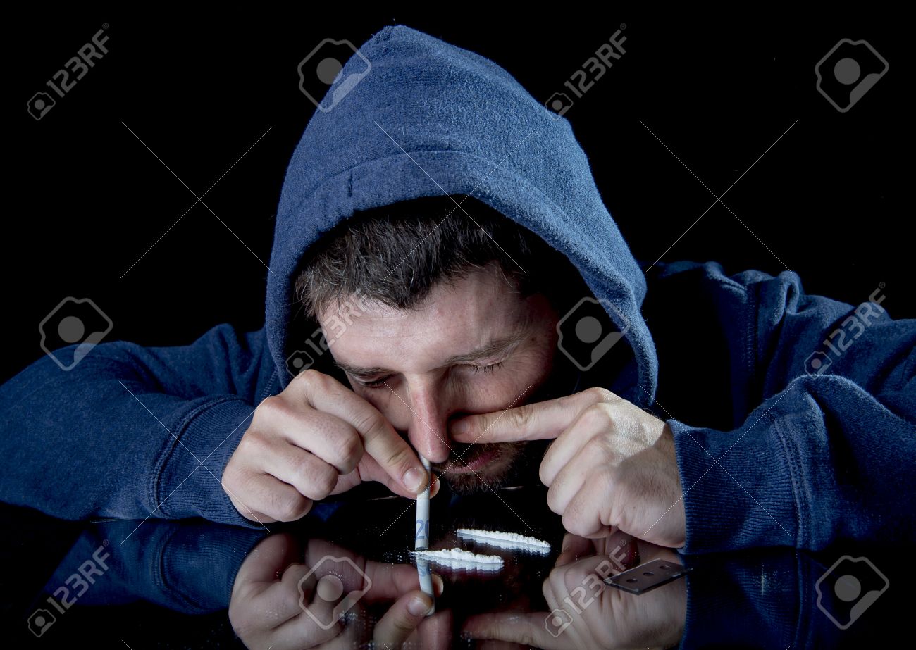 30439612-young-drug-addict-man-on-hood-snorting-cocaine-on-mirror-with-rolled-banknote-at-home-alone-isolated-Stock-Photo.jpg
