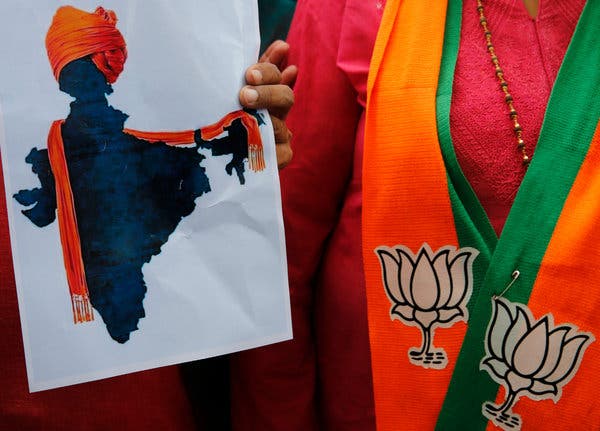 A supporter of India’s revocation of Kashmir’s special status displaying an artist's rendering of a map of India decorated with a shawl of saffron, the dominant color in the ruling Bharatiya Janata Party’s symbol.